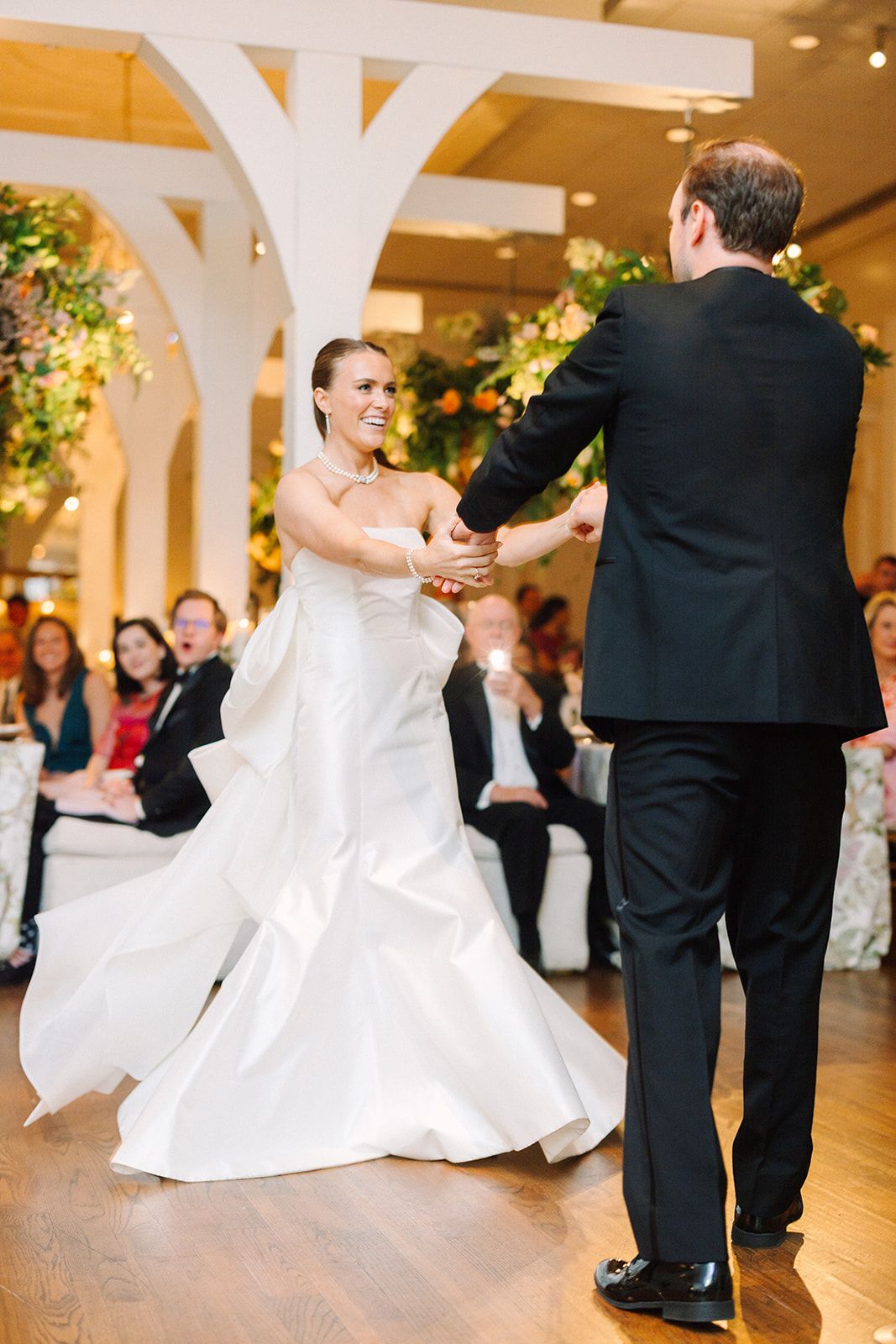 A series of dance photos showing couples twirling and moving gracefully across a polished ballroom floor at a formal event.