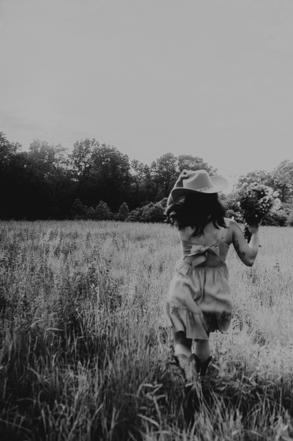 A sequence of five black and white images showing a figure walking through tall grass or wheat fields.