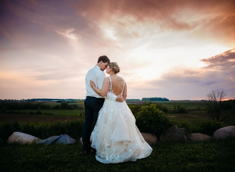 Romantic sunset portrait of newlyweds in countryside setting.