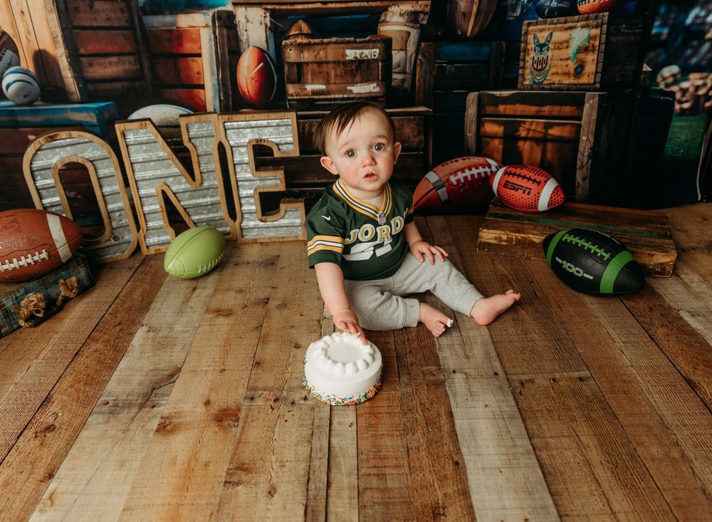 First birthday celebration setup with rustic wooden letters and decorations on hardwood floor.
