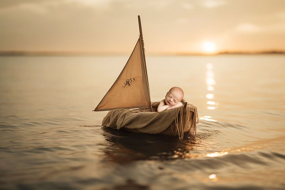 Dreamy portrait in wooden boat during golden hour on peaceful lake.