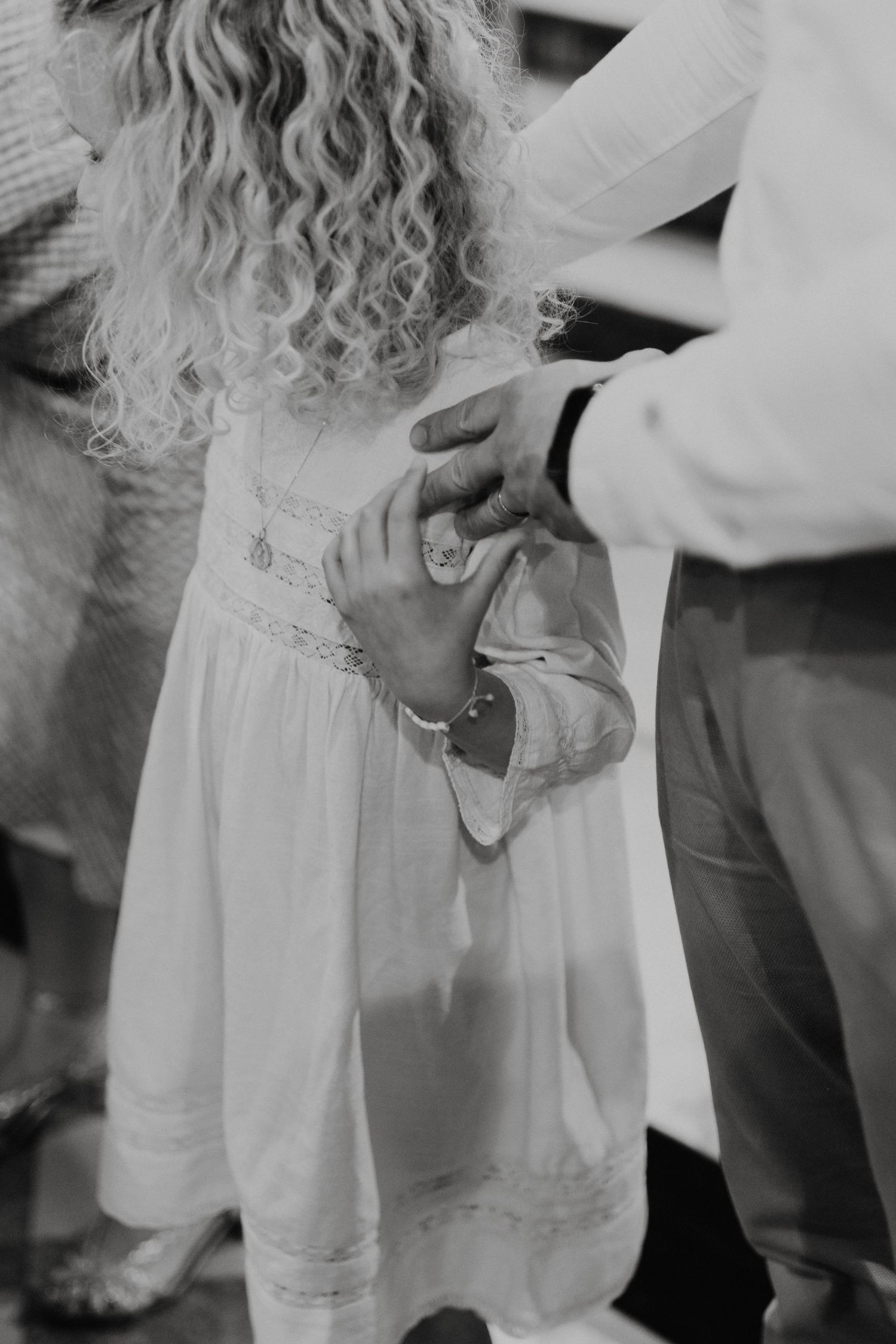 Black and white detail shot of a child's dress being adjusted.