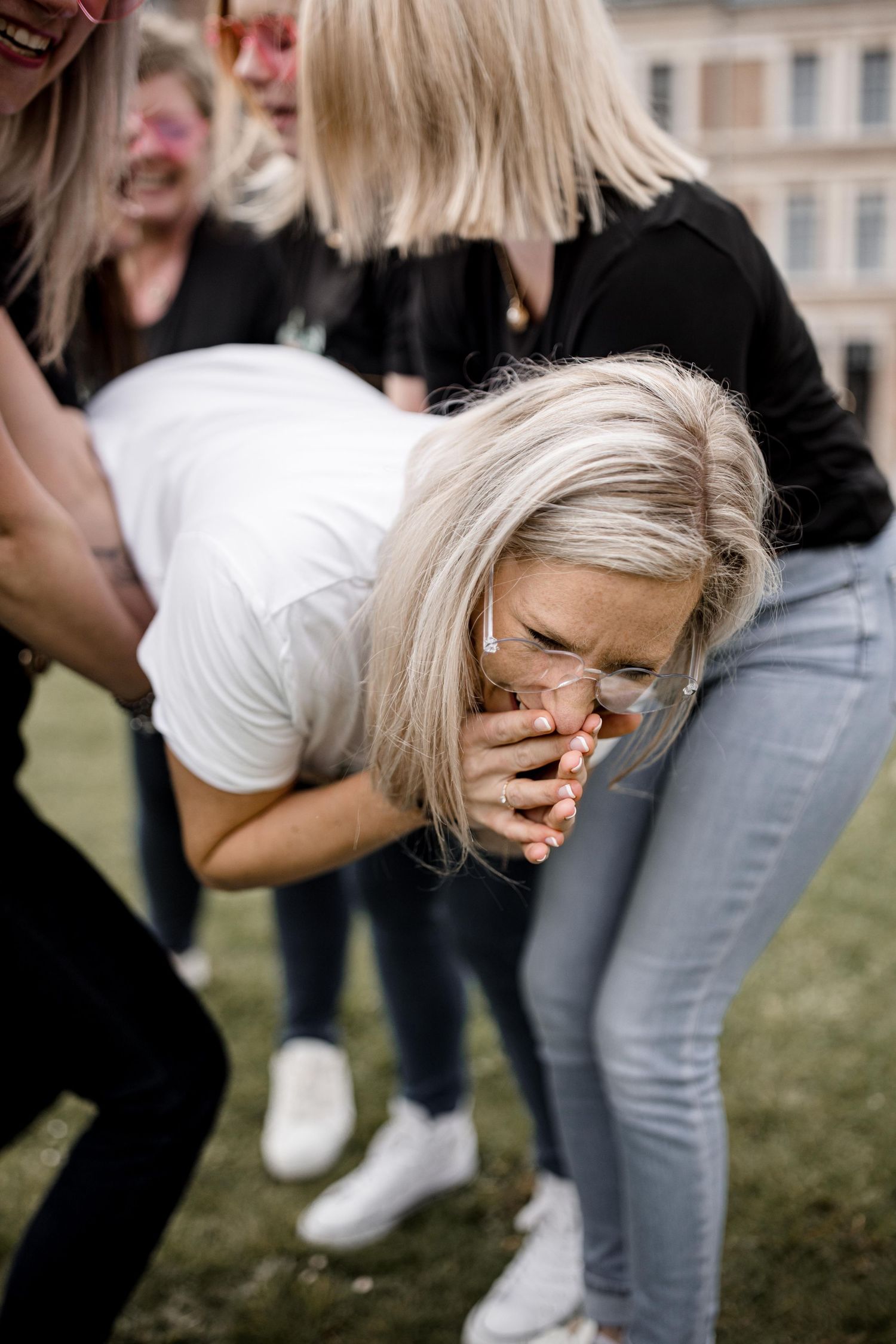 Group of friends laughing and having fun outdoors in casual attire.