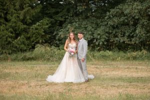 Outdoor wedding portrait of couple standing together in natural garden setting.