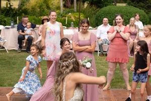 A playful moment during the wedding reception on a wooden dance floor.