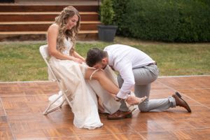 A groomsman celebrates on the dance floor at an outdoor wedding reception.