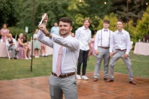 Groomsmen performing choreographed dance moves at an outdoor wedding reception.