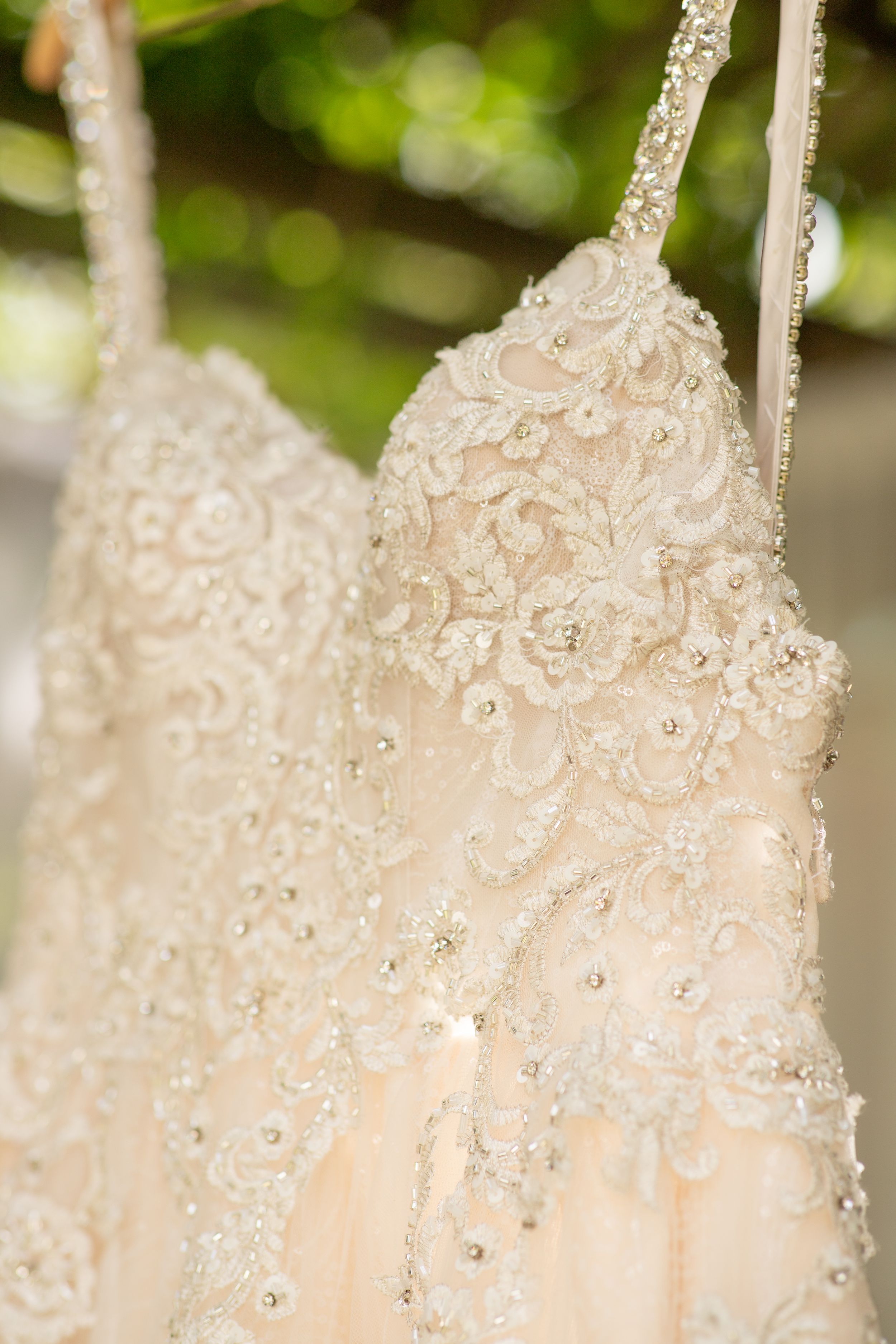 Close-up of an intricately beaded and lace wedding dress bodice.