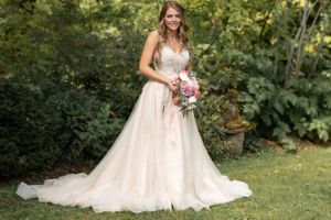 Full-length outdoor bridal portrait with flowing tulle gown and cascading bouquet.