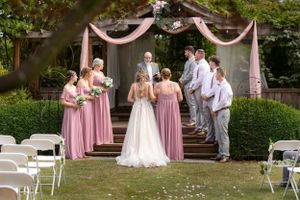 Bride, wedding party, groom during wedding ceremony.