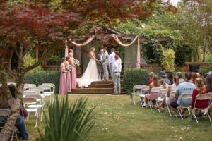 Outdoor wedding ceremony garden style showing wedding party.