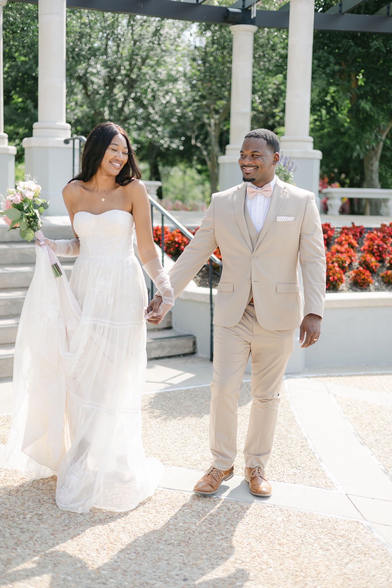 Bride looking shy as she holds her grooms hand on their wedding day at their garden wedding in Tampa