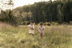 two little boys running in a field