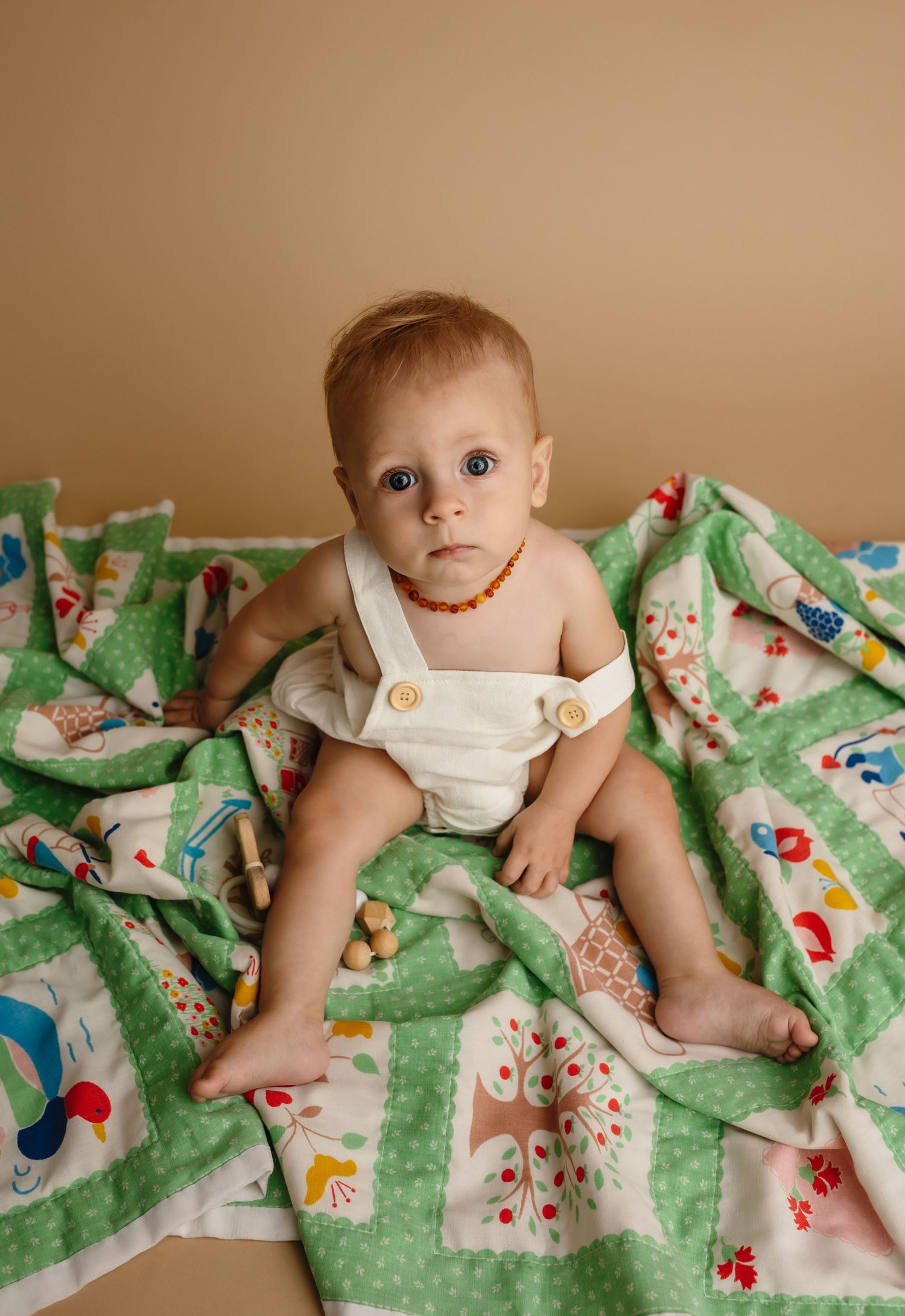 Harrisonburg photographer, baby, newborn, family, maternity, baby boy sitting on green quilt with necklace and blue eyes