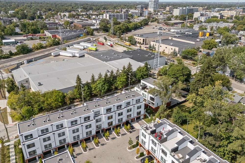 Aerial view of modern multi-story townhome development with rooftop terraces in urban neighborhood.