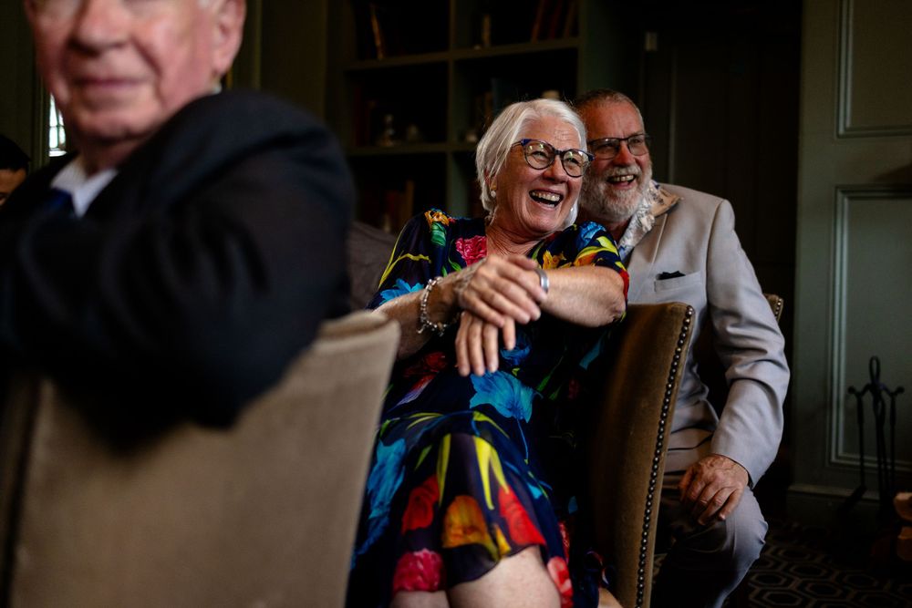 A joyful moment of laughter and celebration at an indoor gathering wearing colorful attire.