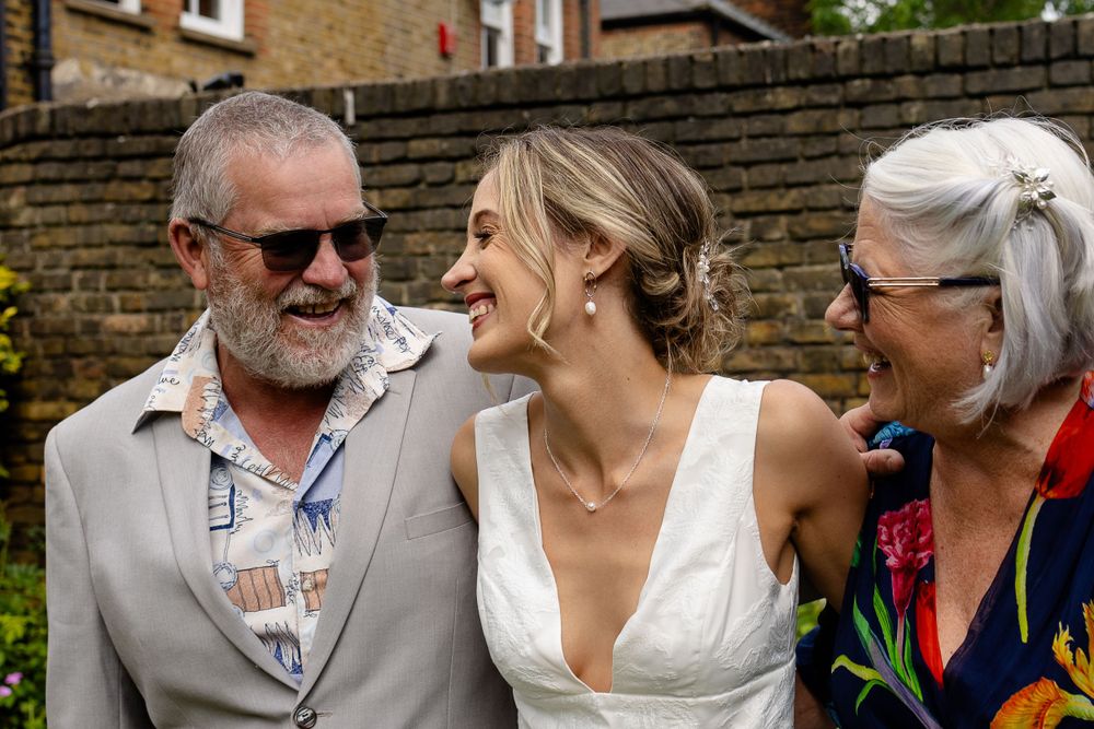 Candid outdoor moment showing joyful interaction between wedding guests and couple.