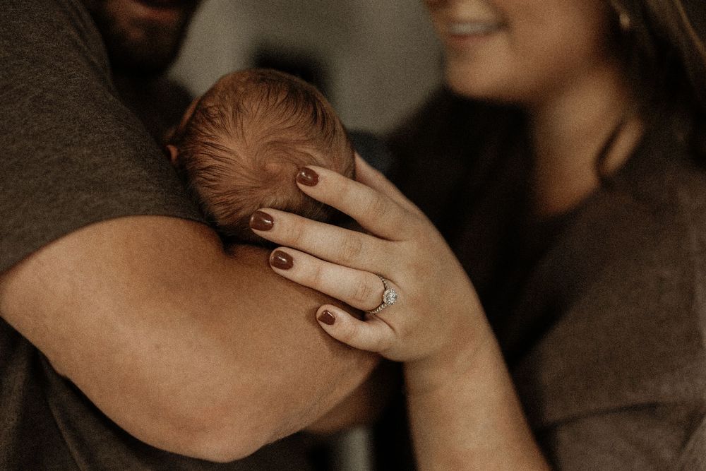 A tender intimate moment captured in a romantic close-up portrait against a dark background.