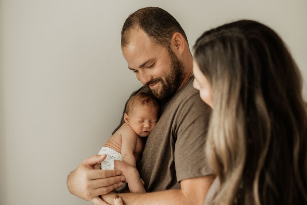 Intimate family photography session showing tender moments with a newborn.