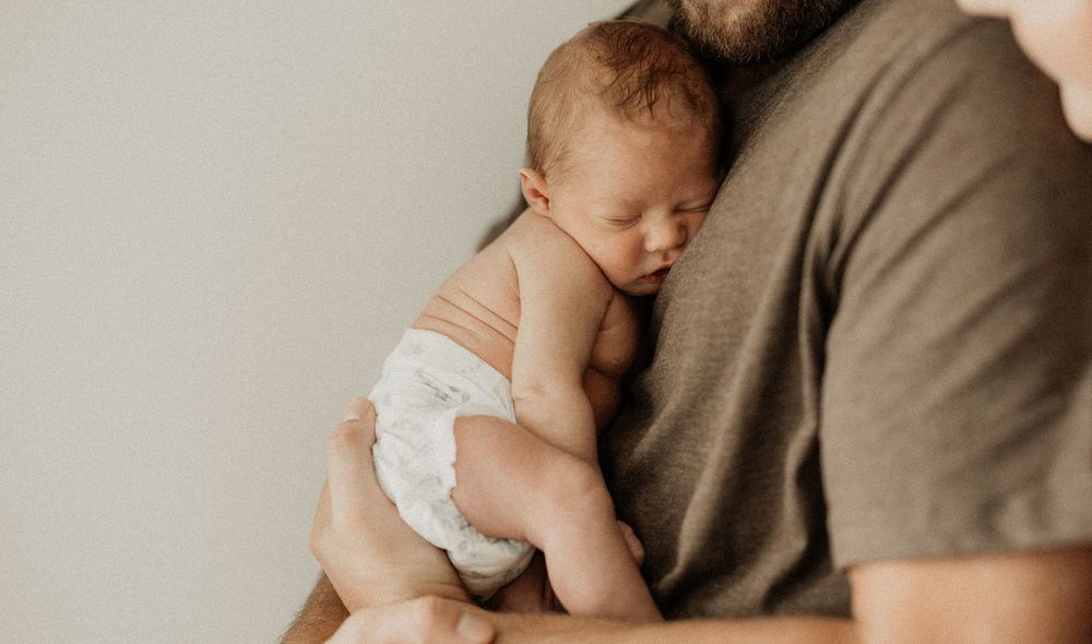 Series of tender moments between parents and their sleeping newborn baby.
