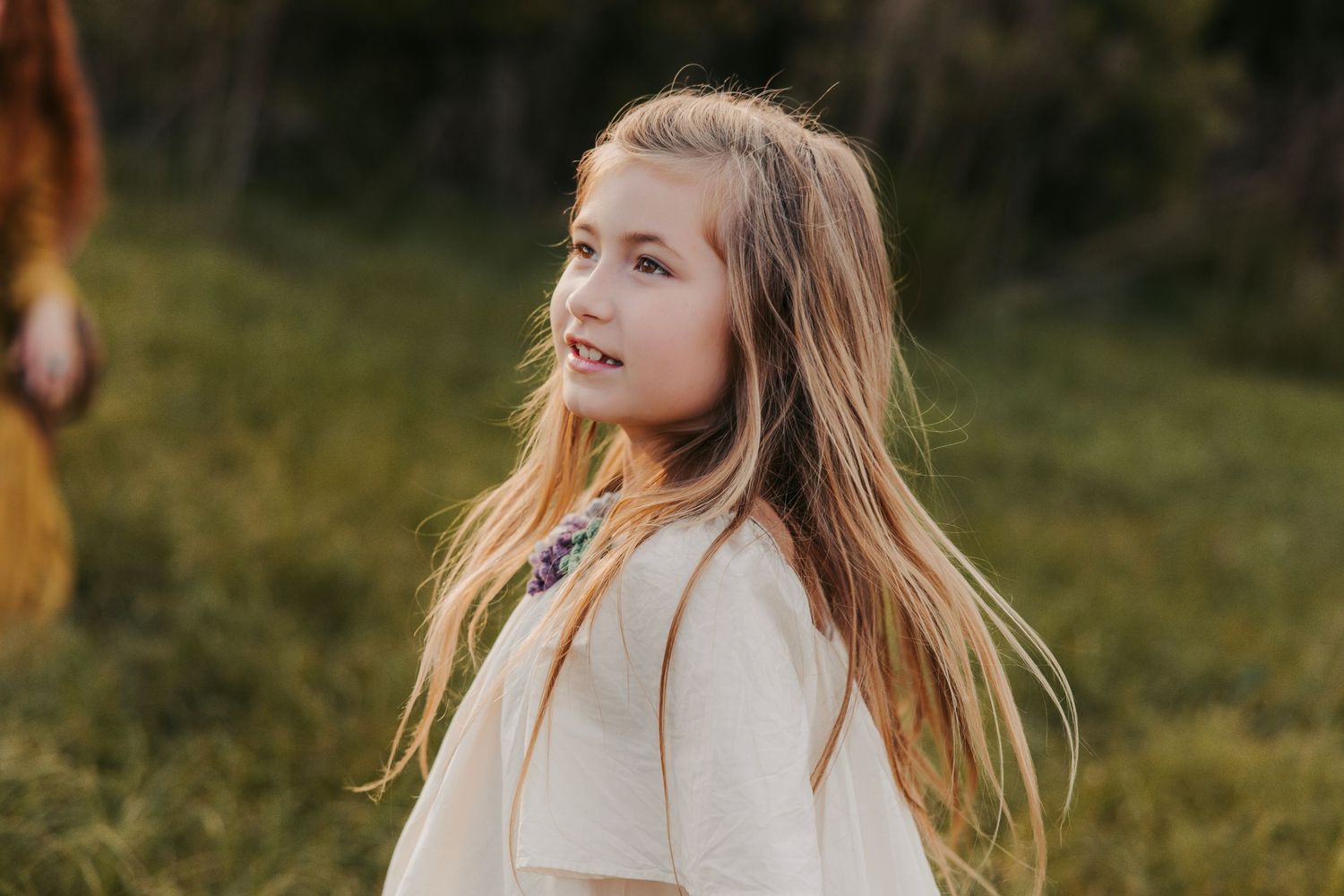 Sunlit outdoor portrait session with soft natural lighting and grass background.