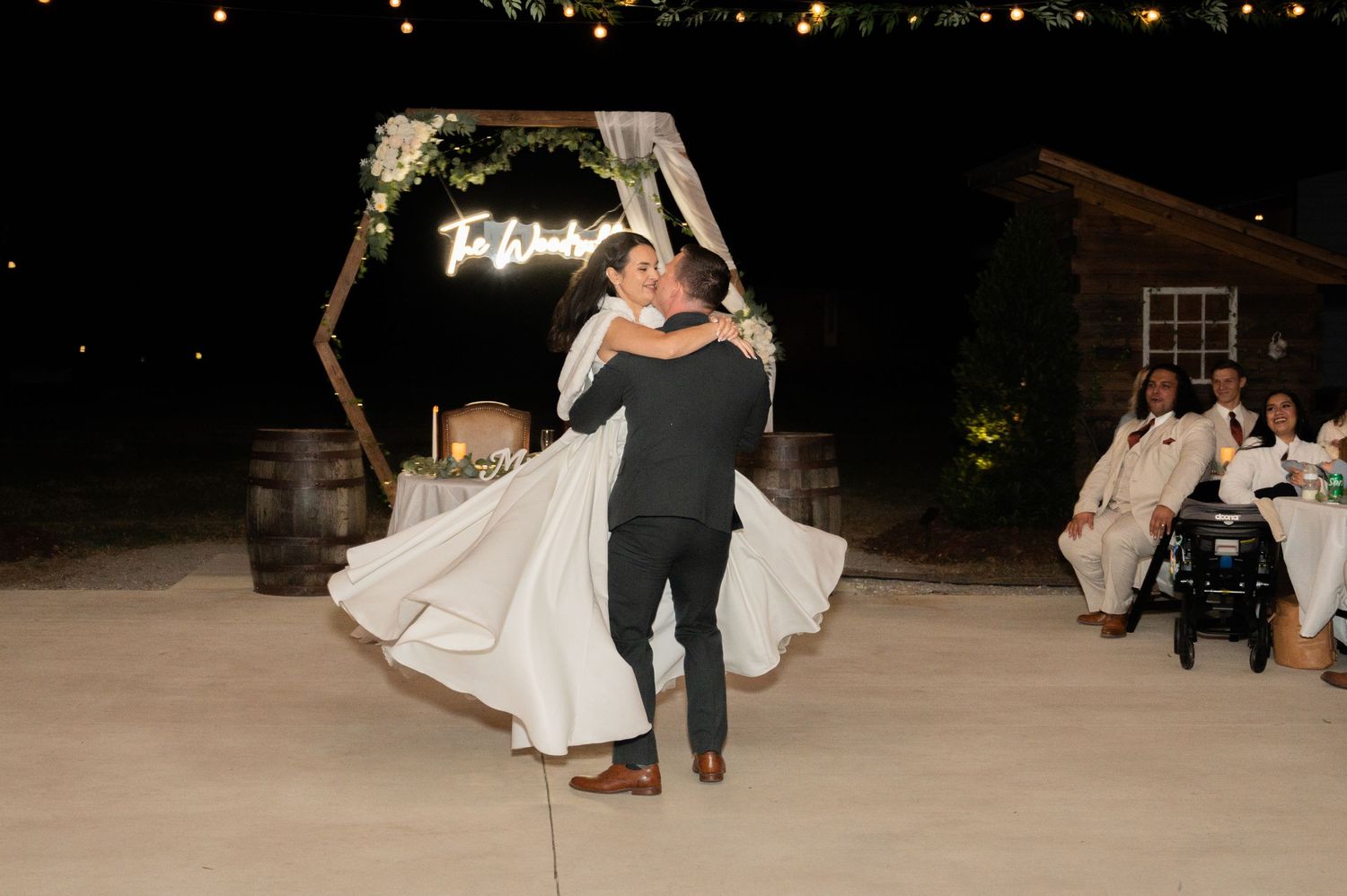 Wedding reception dance floor scene at night with string lights creating a romantic ambiance.