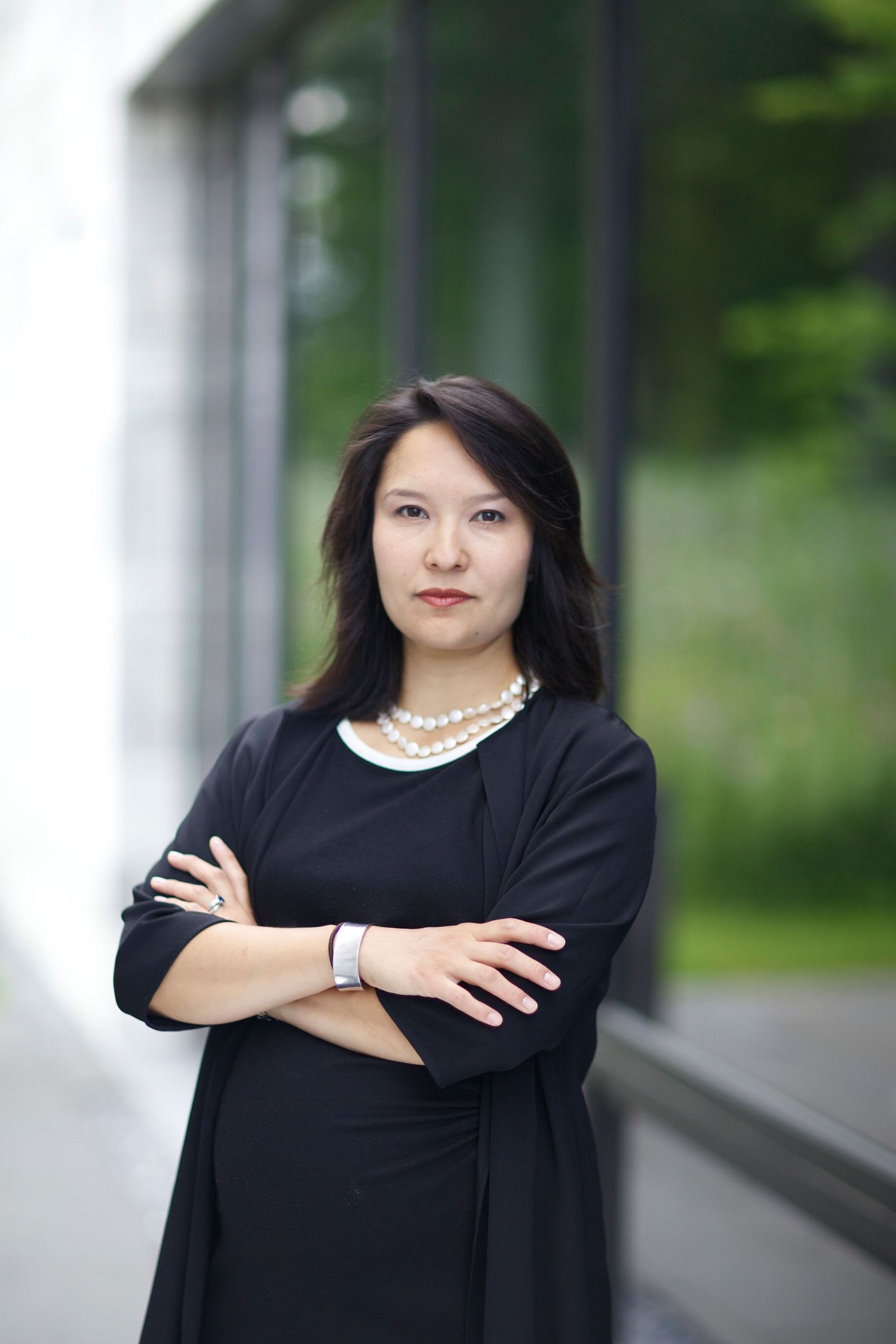 Editorial portrait of Mariko Silver, arts leader and former college president, posed against contemporary architectural backdrop.