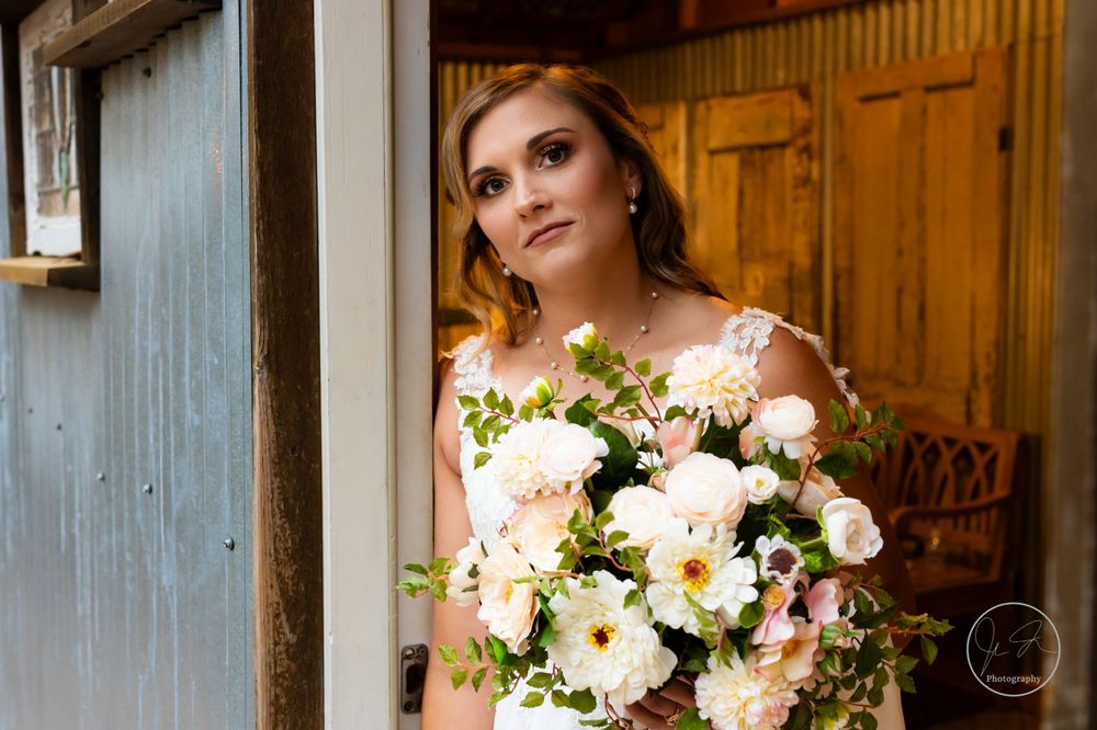 Portrait of bride-to-be standing in doorway holding bouquet