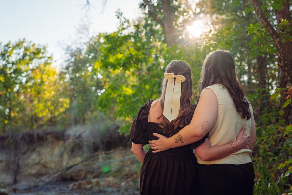 Two people share an intimate moment at sunset with one holding a book in front of their face.