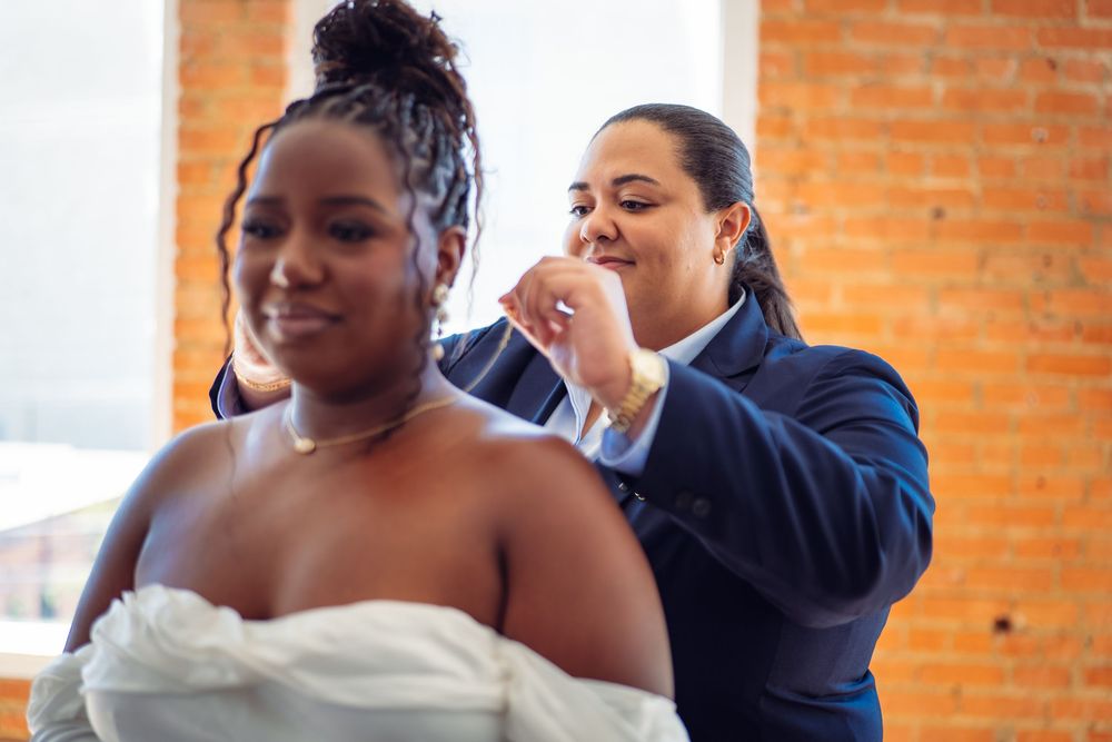 Wedding couple sharing an intimate dance in an industrial-style venue with brick walls and natural lighting.