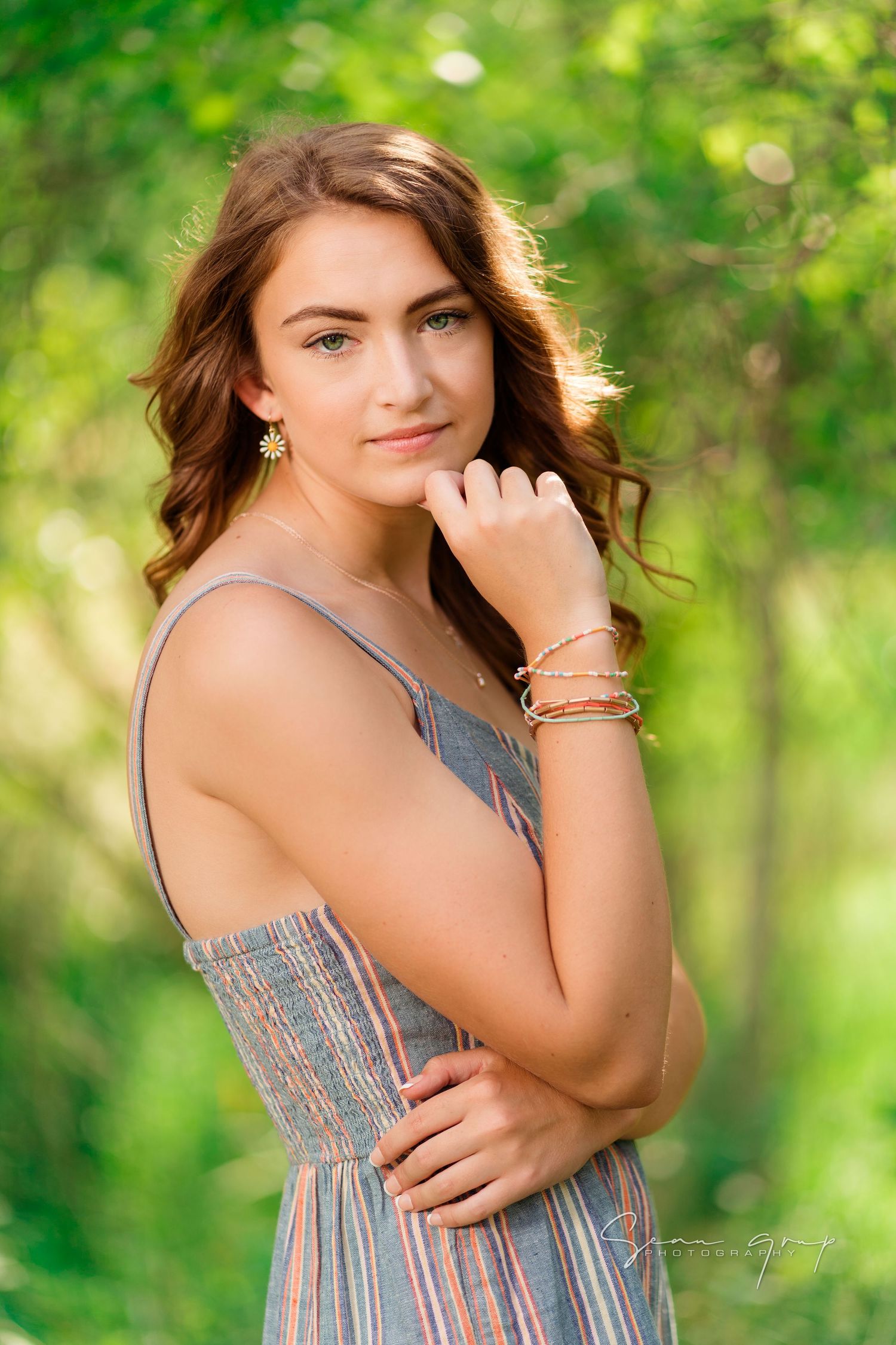Summer portrait session in a lush green forest setting with soft natural lighting.