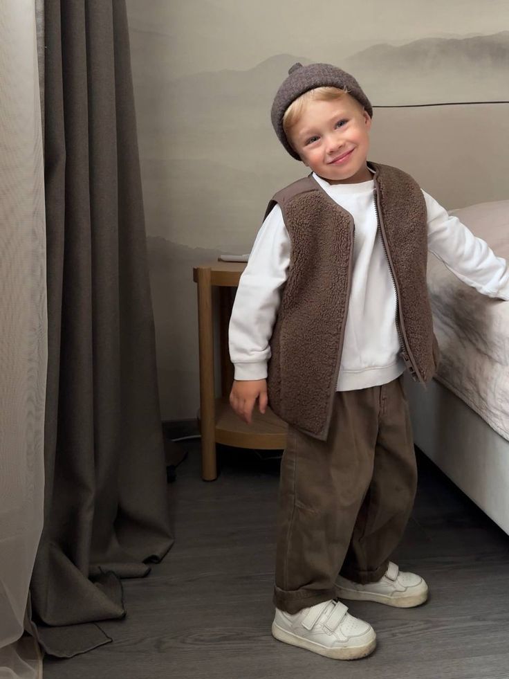 Brown knit vest and white shirt outfit shown from various angles on gray floor near window.