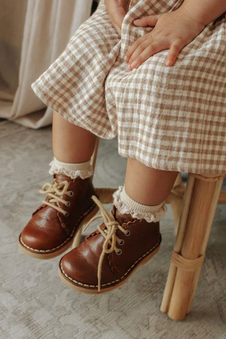 Close-up sequence of vintage brown leather baby shoes with laces shown from different angles on wooden furniture.