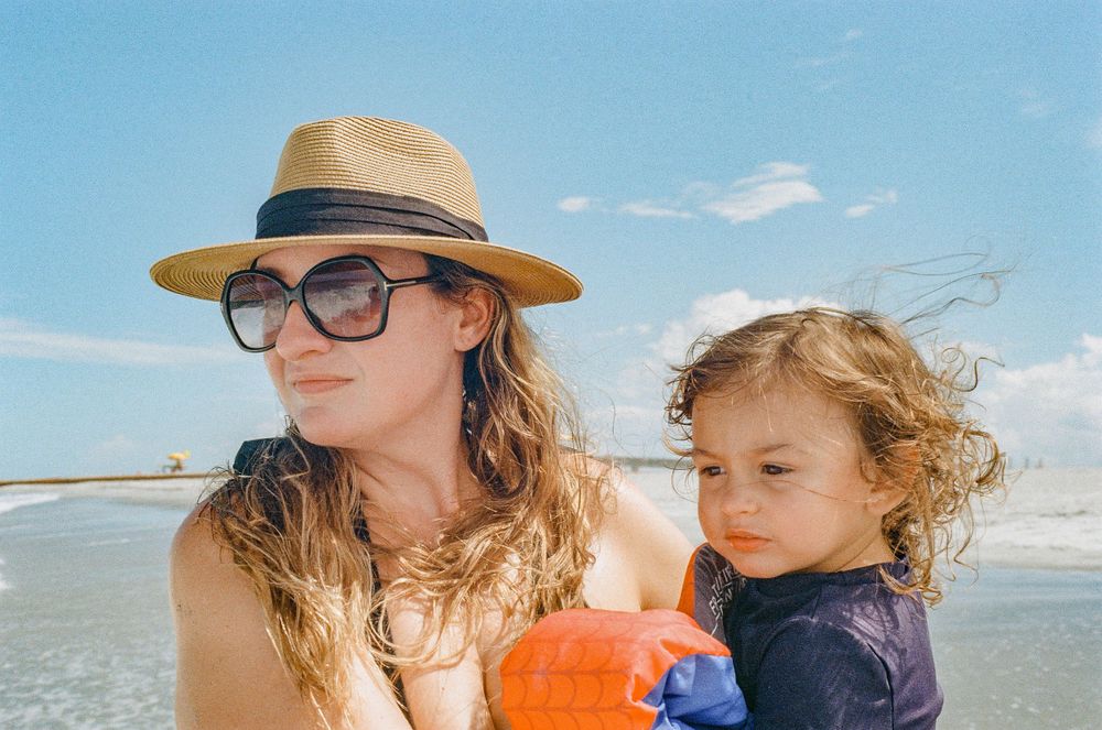 A sunny beach scene with straw hats and an orange floatation device.