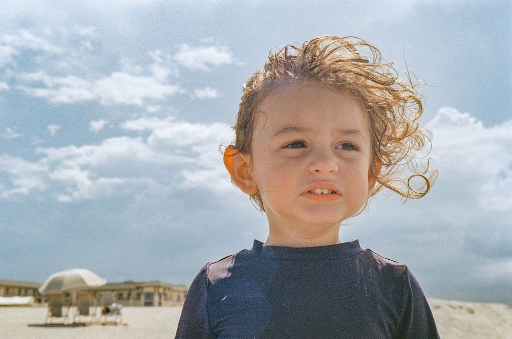 Young beachgoer enjoying a sunny day by the ocean.