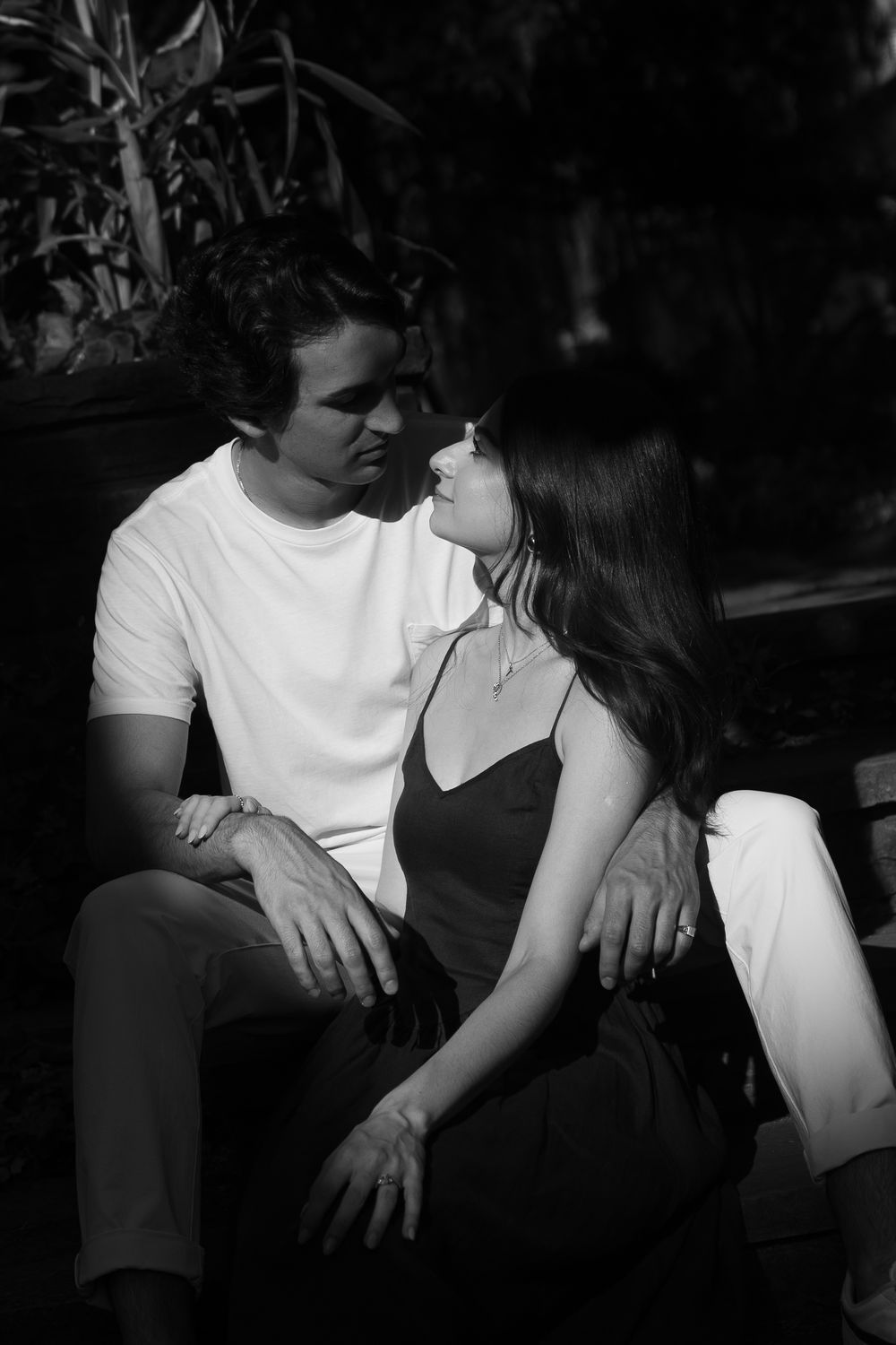 A romantic black and white photo sequence showing a couple sitting close together in intimate poses.
