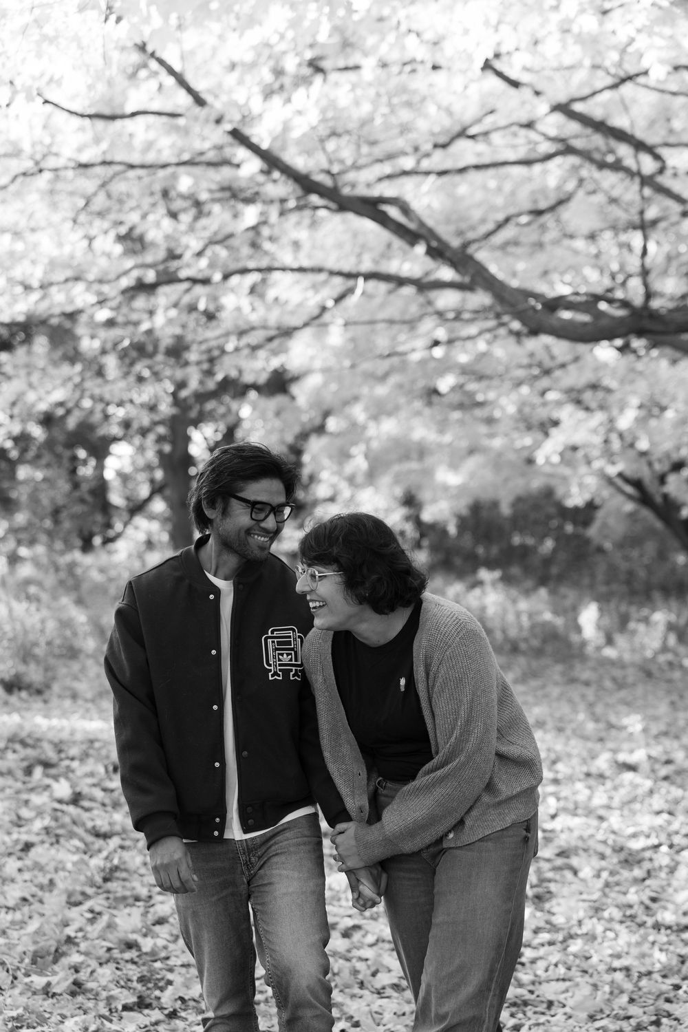 A series of black and white photos showing people bending down to look at something in a park setting.