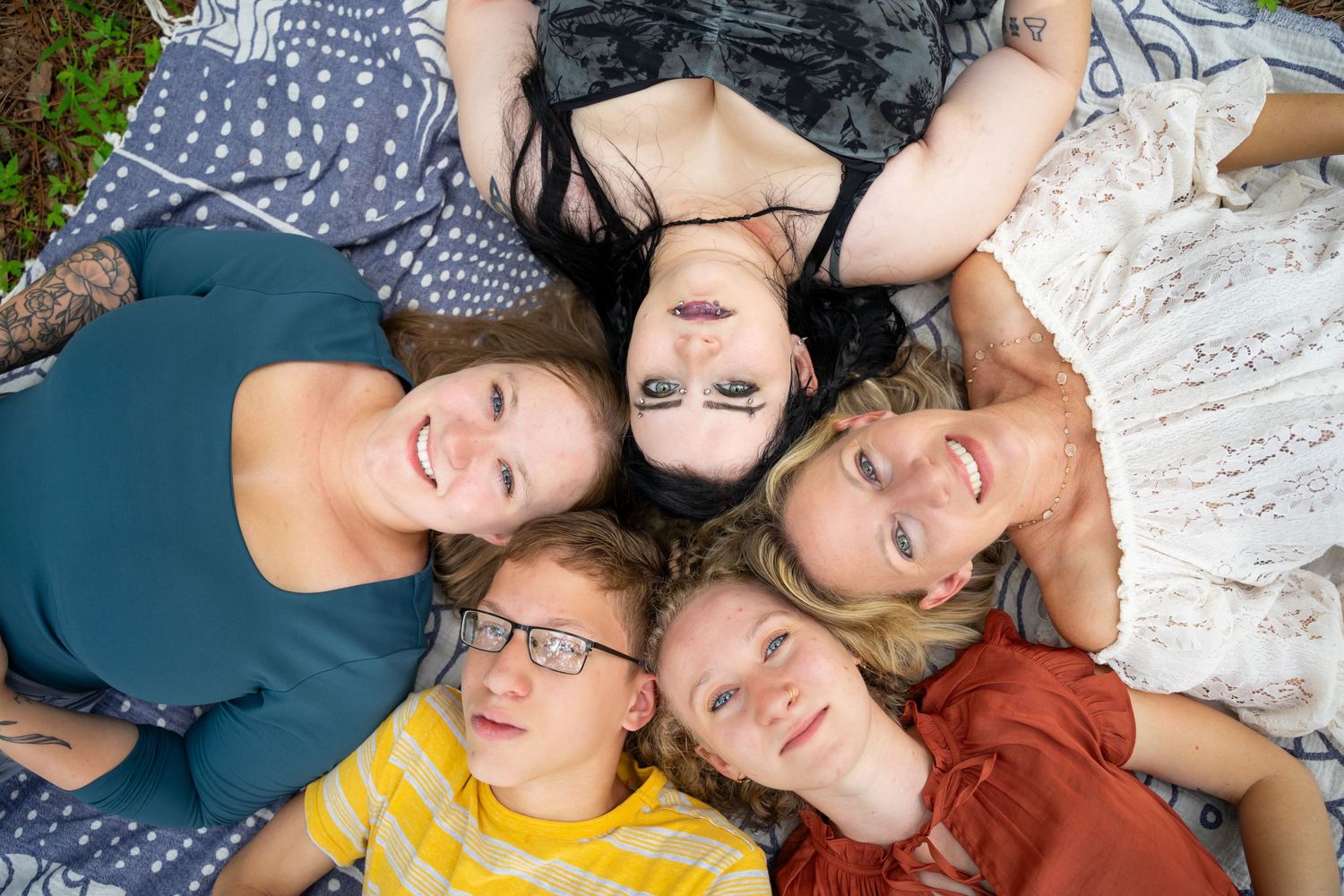 Group lying down together on floor creating playful photo composition.