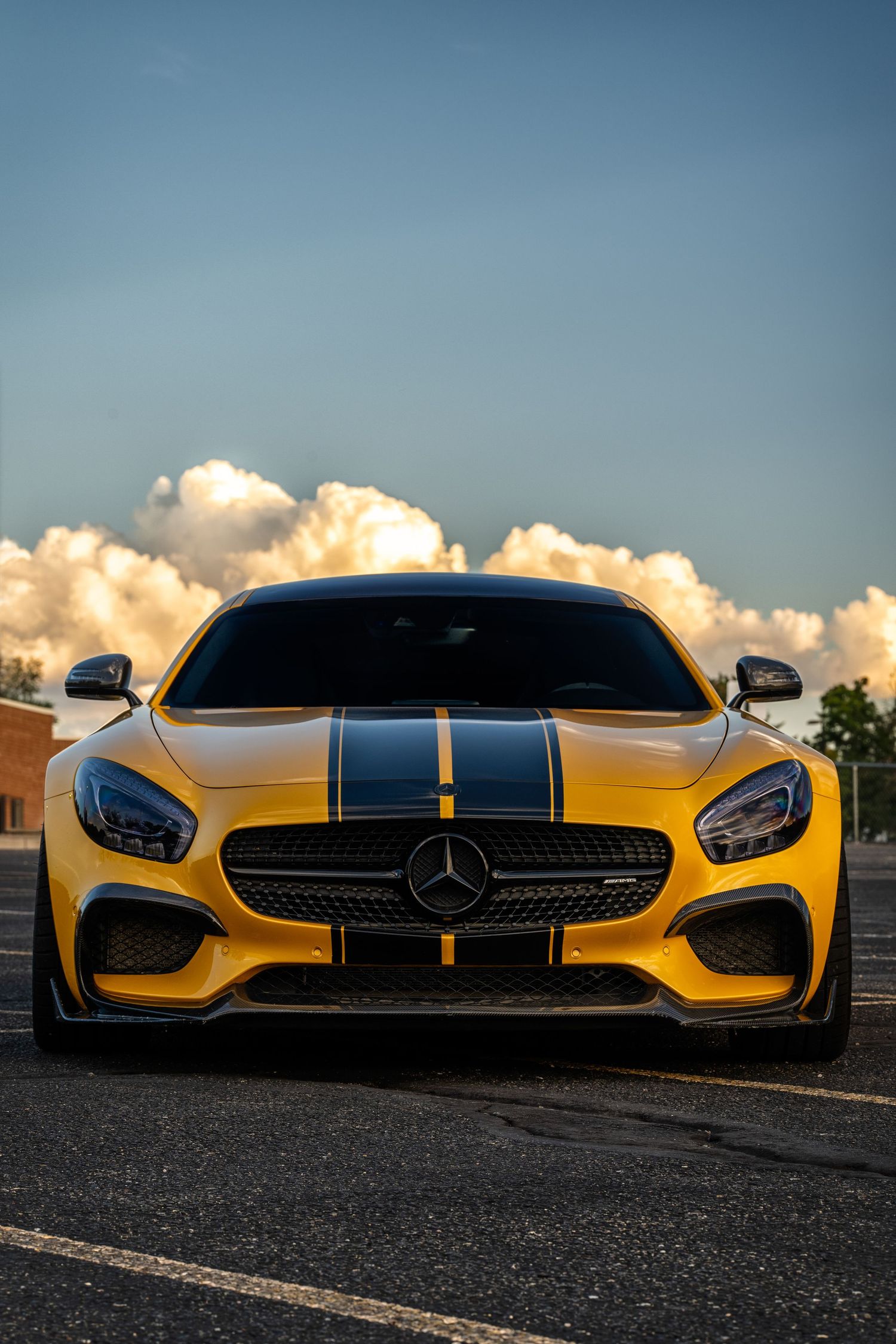 Mercedes AMG with big clouds and blue sky in the background