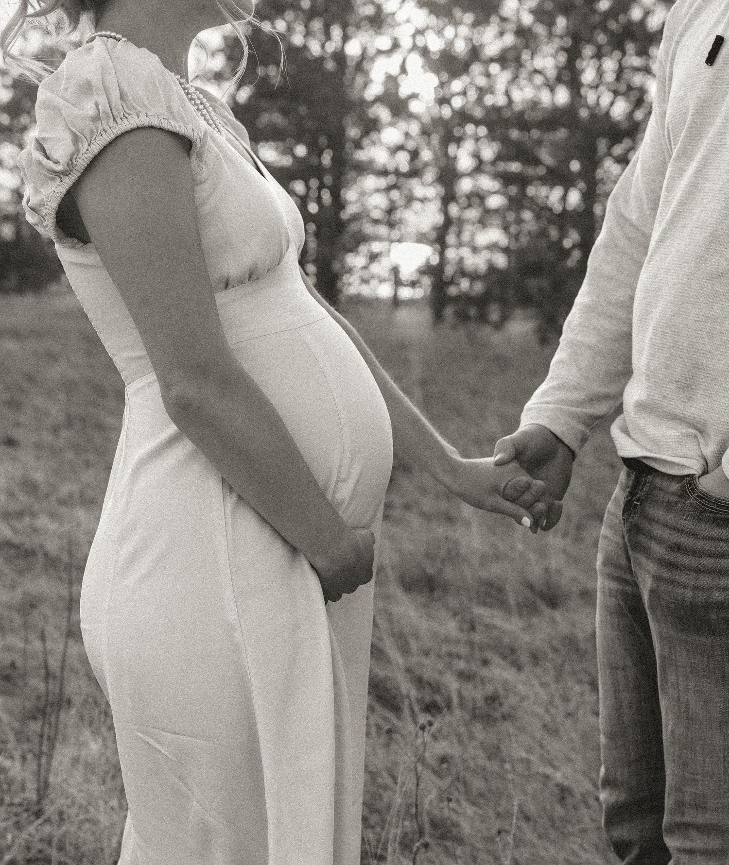 Garrison North Dakota maternity photography of couple holding hands in black and white with faces intentionally not visible Garrison, ND