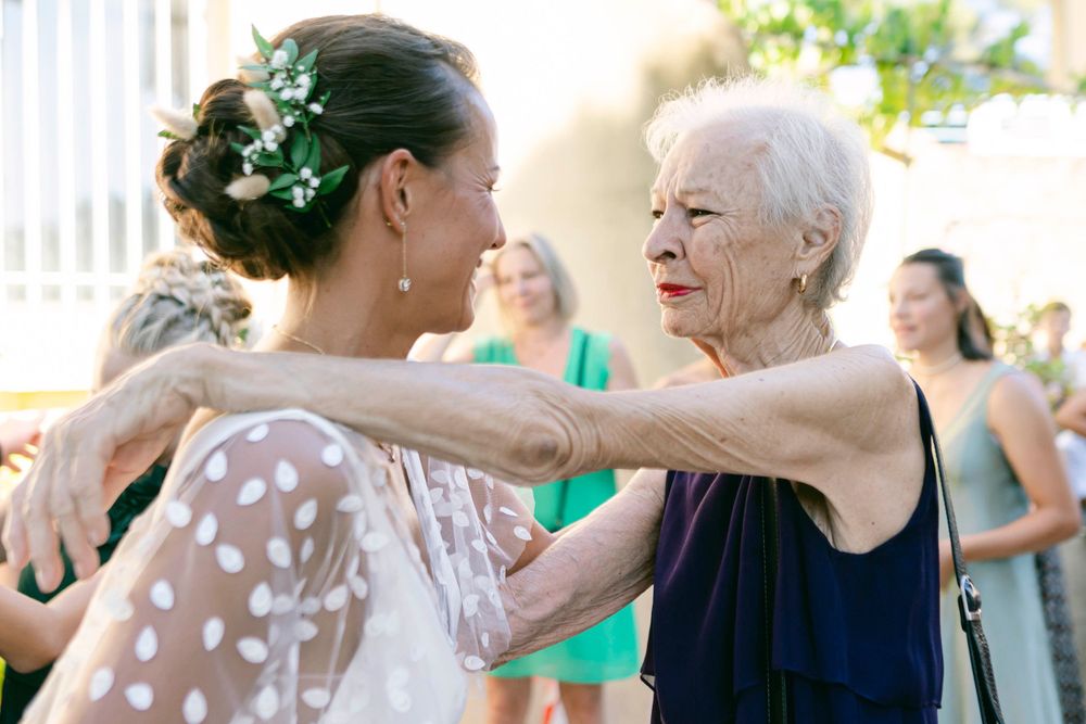 An emotional embrace is shared during wedding celebrations outdoors.