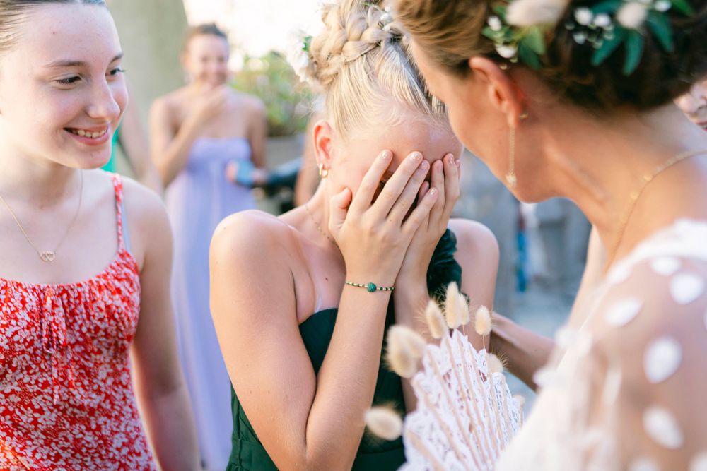 An emotional moment is captured between wedding guests during the celebration.