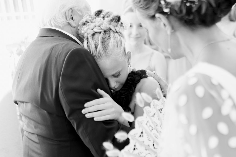 A tender emotional moment is shared during wedding celebrations, captured in black and white.