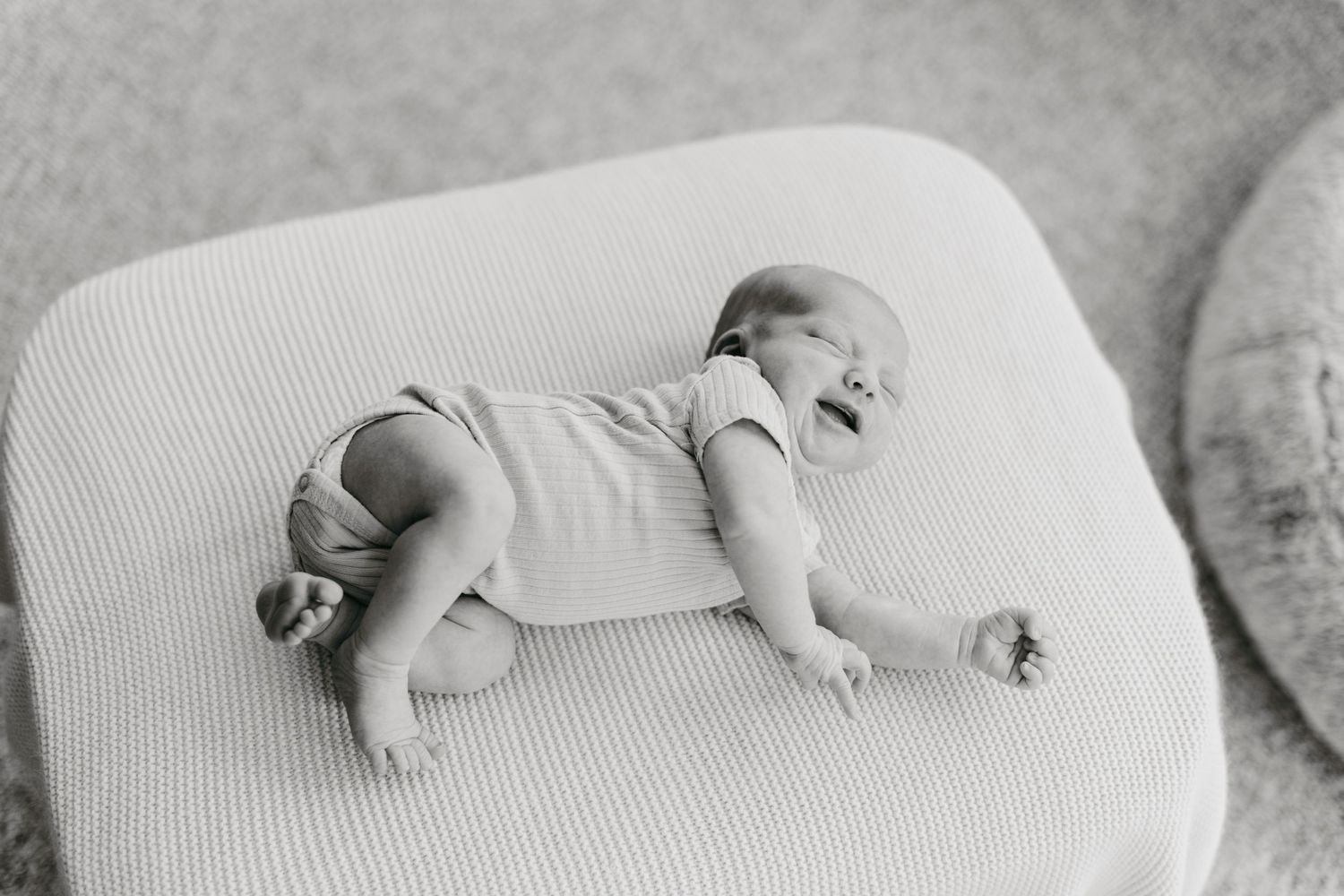 Newborn baby girl happy and candid laying down in black and white in Akron, Ohio and Northeast, Ohio lifestyle photography session.