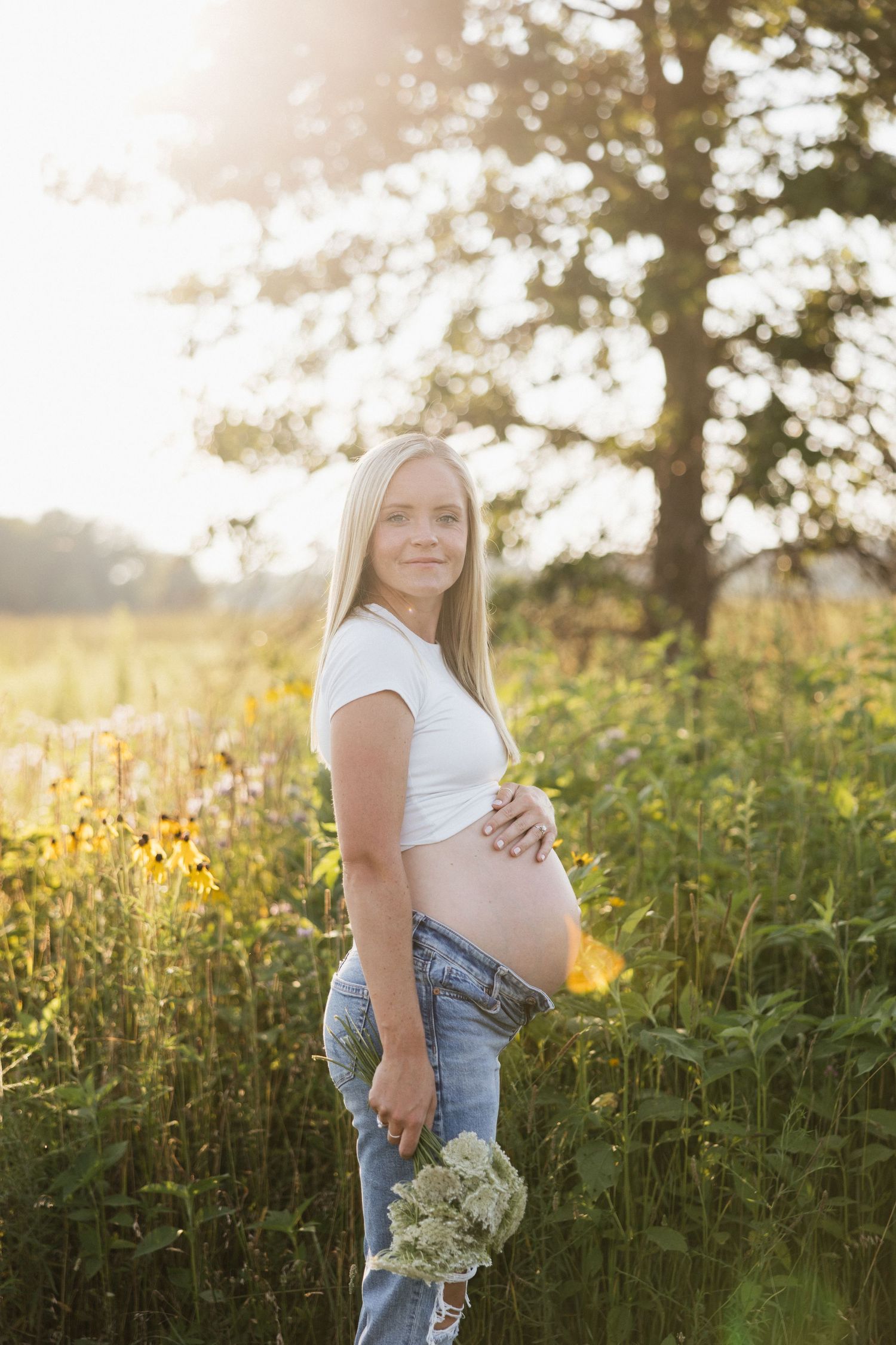 Flower bouquet maternity photography session with pregnant woman at sunset in a field in Akron, Ohio.