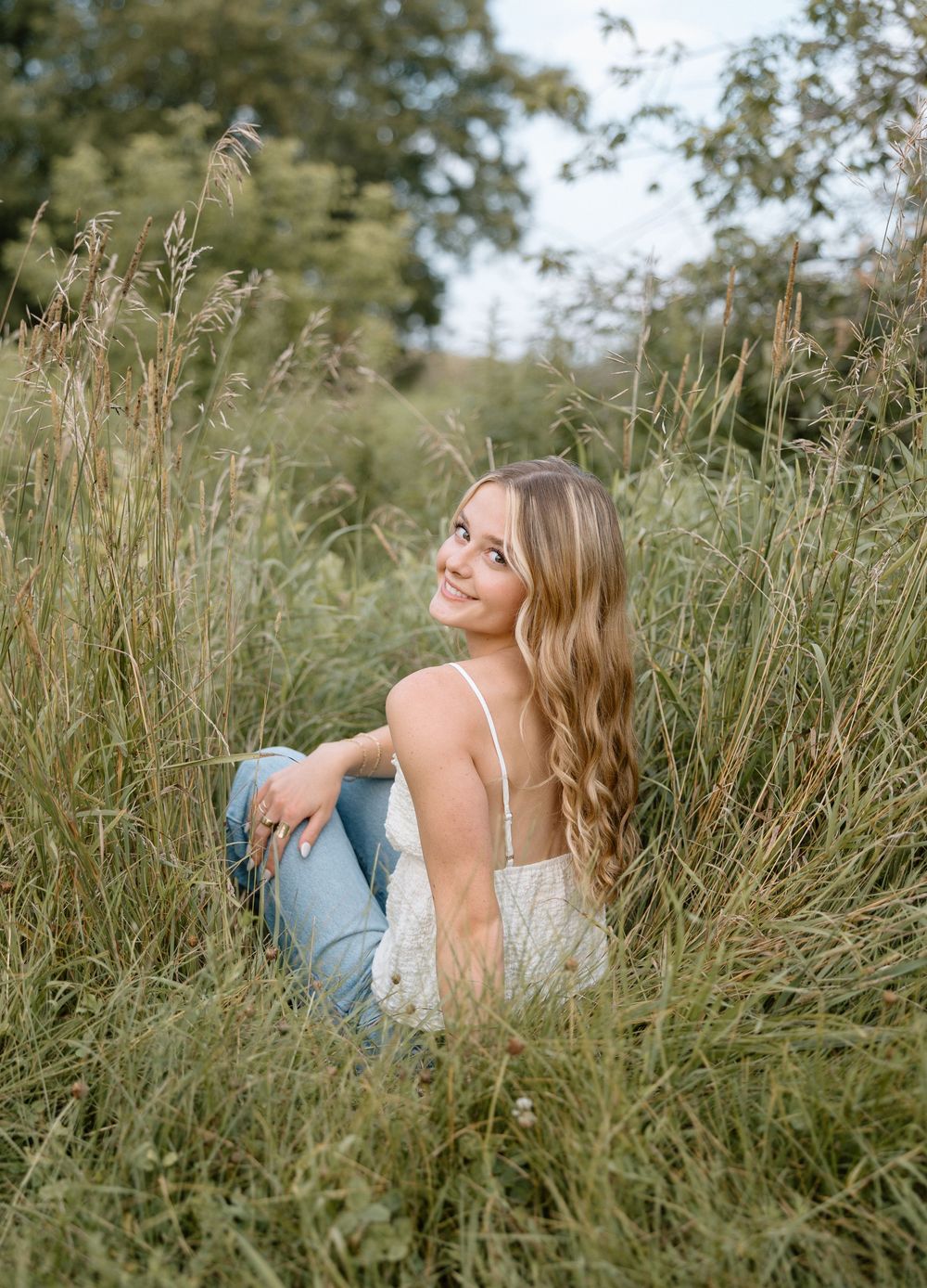 Relaxed portrait session in a natural meadow with tall grass.