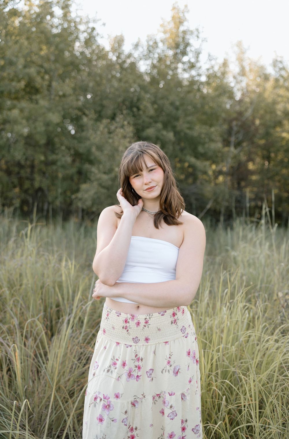 A dreamy portrait session in tall grass with a floral dress and white top.