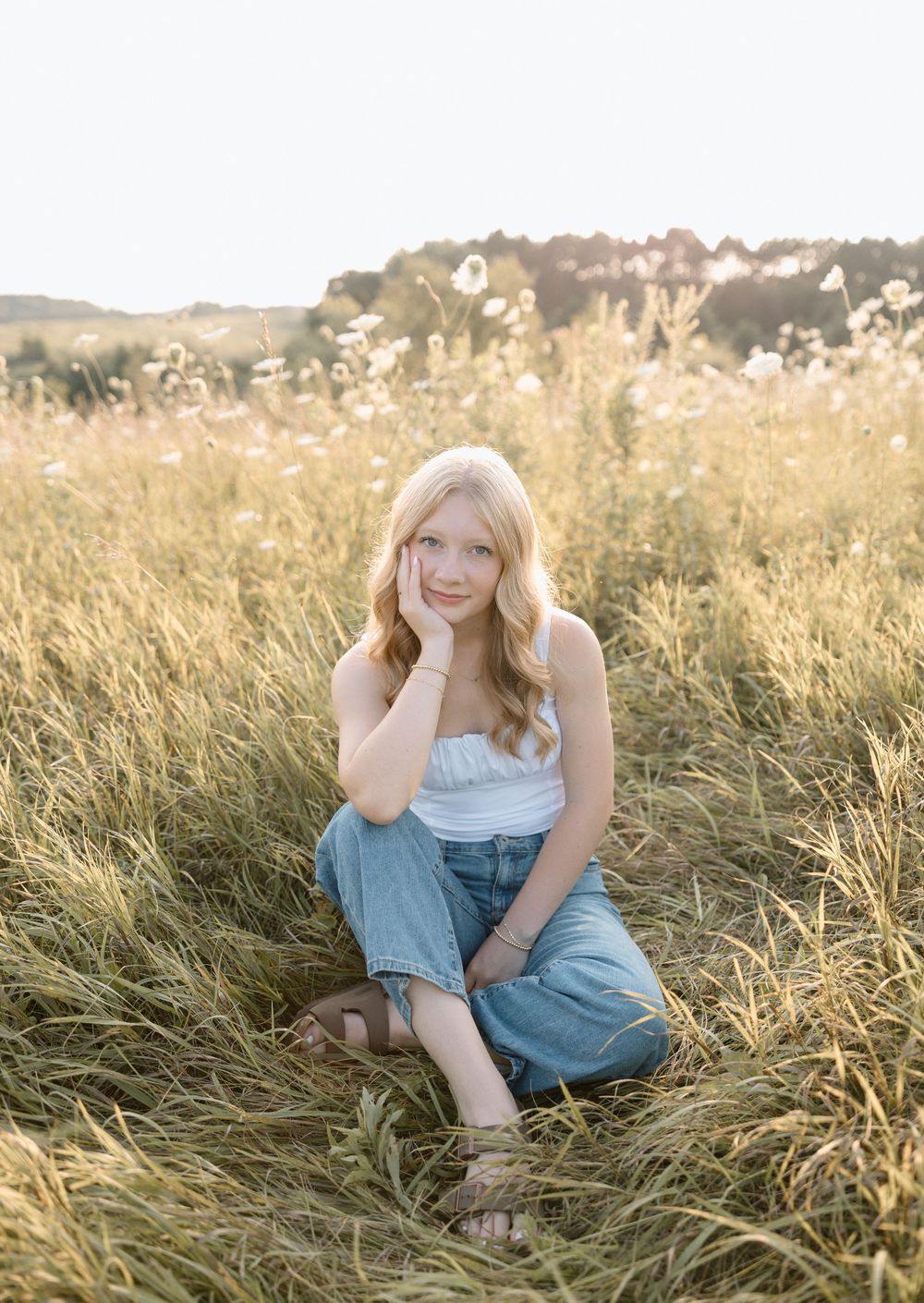 Playful summer portraits taken in a sunlit meadow with long grass.