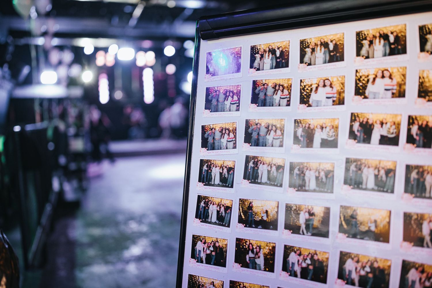 Display screen showing grid of event photography thumbnails in dim lighting.