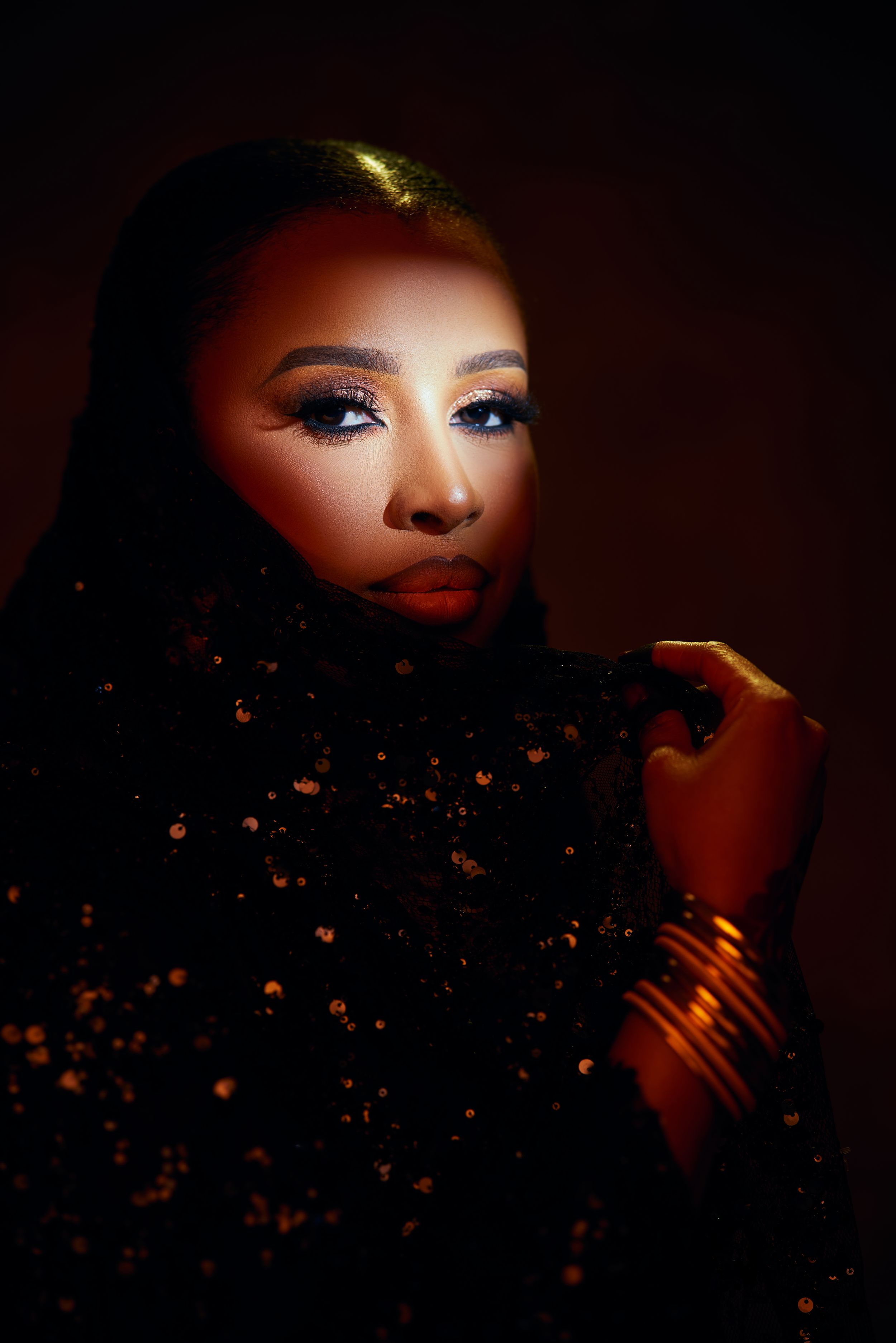 Dramatic beauty portrait with sparkles against dark background.